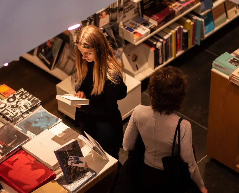 Colour photograph of two people browsing books in the shop