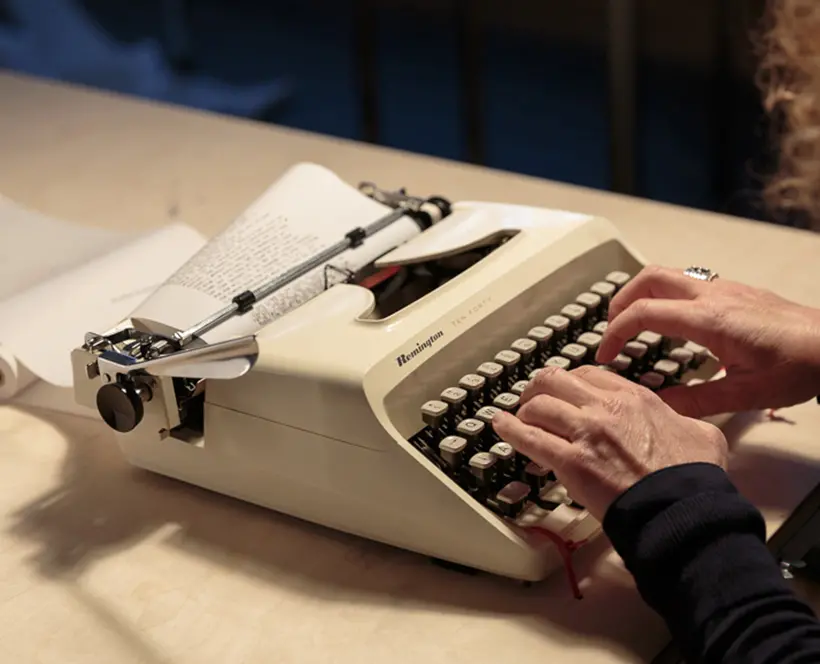 A person typing on a typewriter 