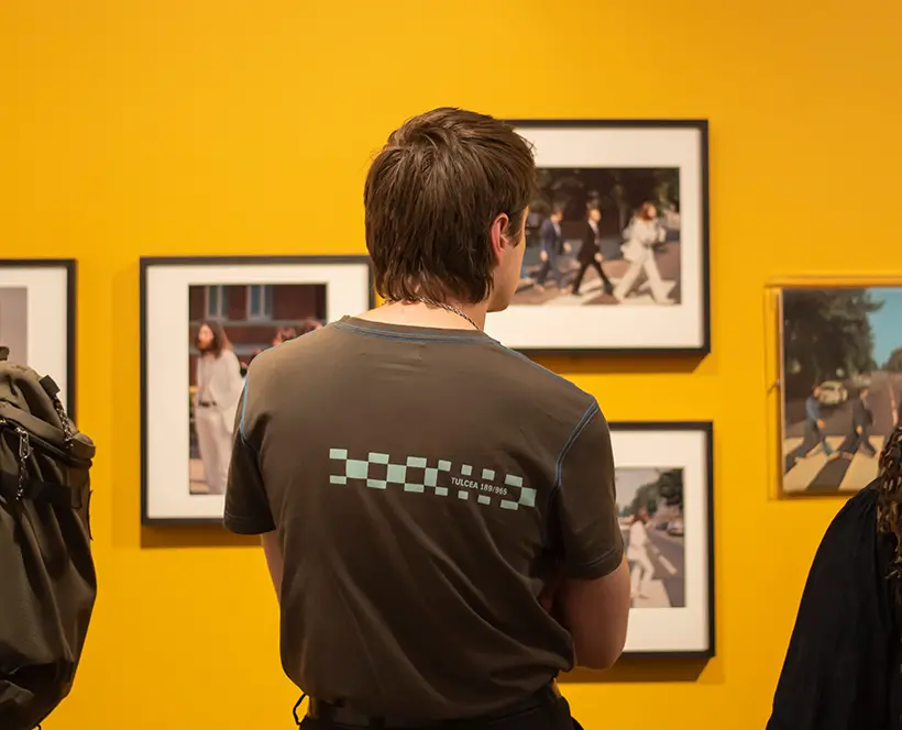 A person in a Gallery looking at framed images in an exhibition