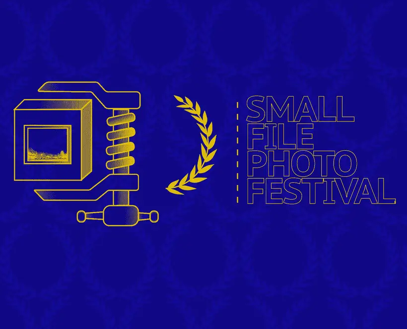 A clamp holding box that contains a photograph of landscape. "Small File Photo Festival" surrounded by award laurels